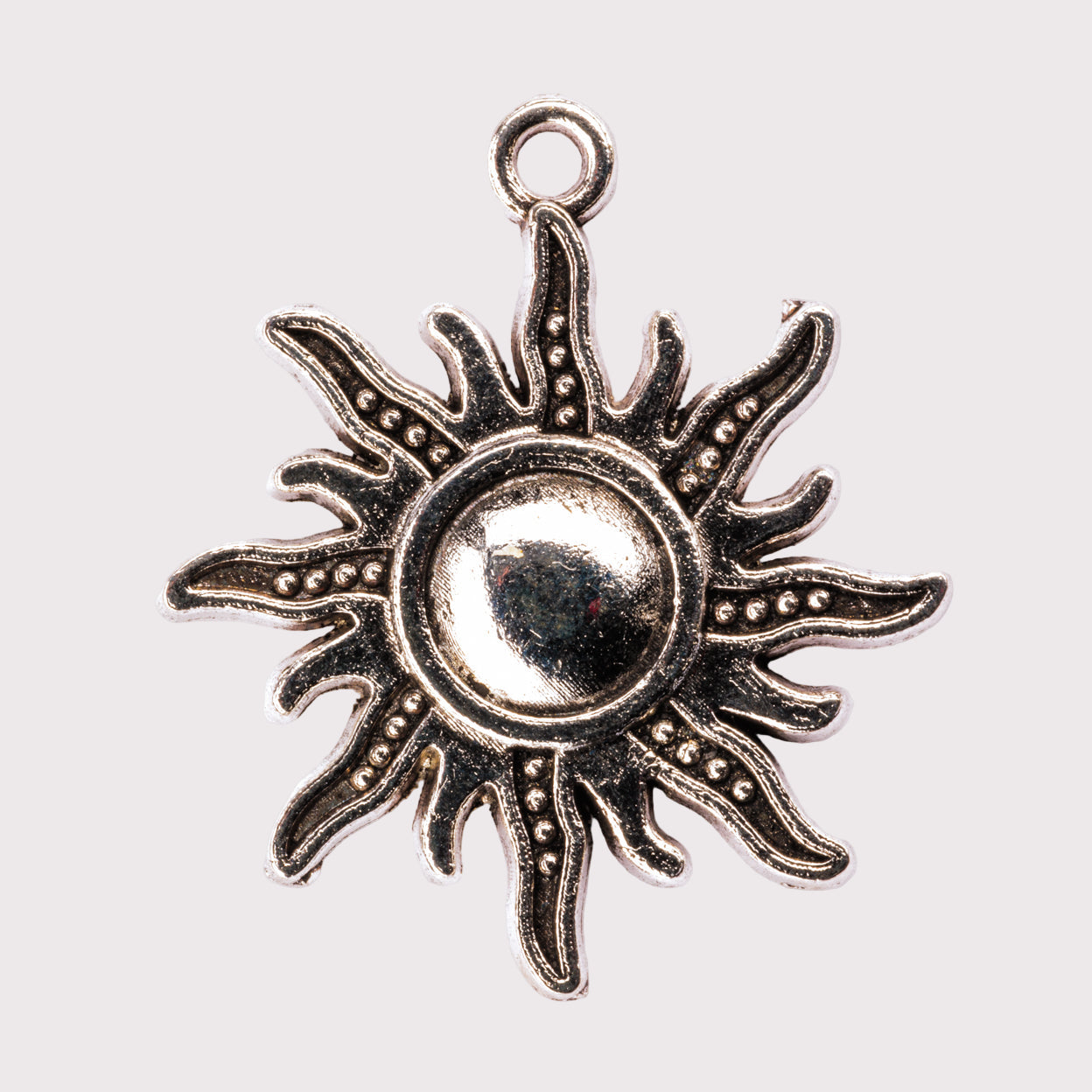 A silver-colored metal charm shaped like a sun with a loop for attachment, against a white background.
