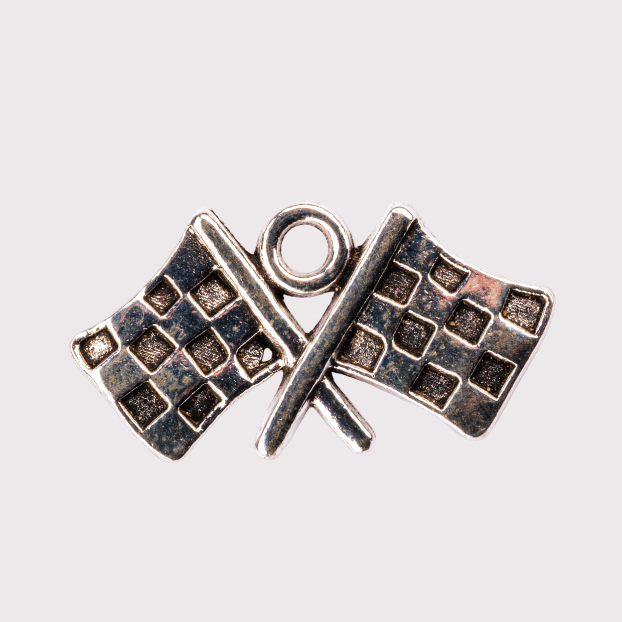 A silver-colored metal charm featuring two checkered flags crossed over each other.