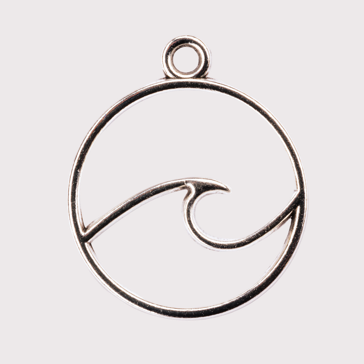 A silver-colored metal charm with a wave design inside a circle.