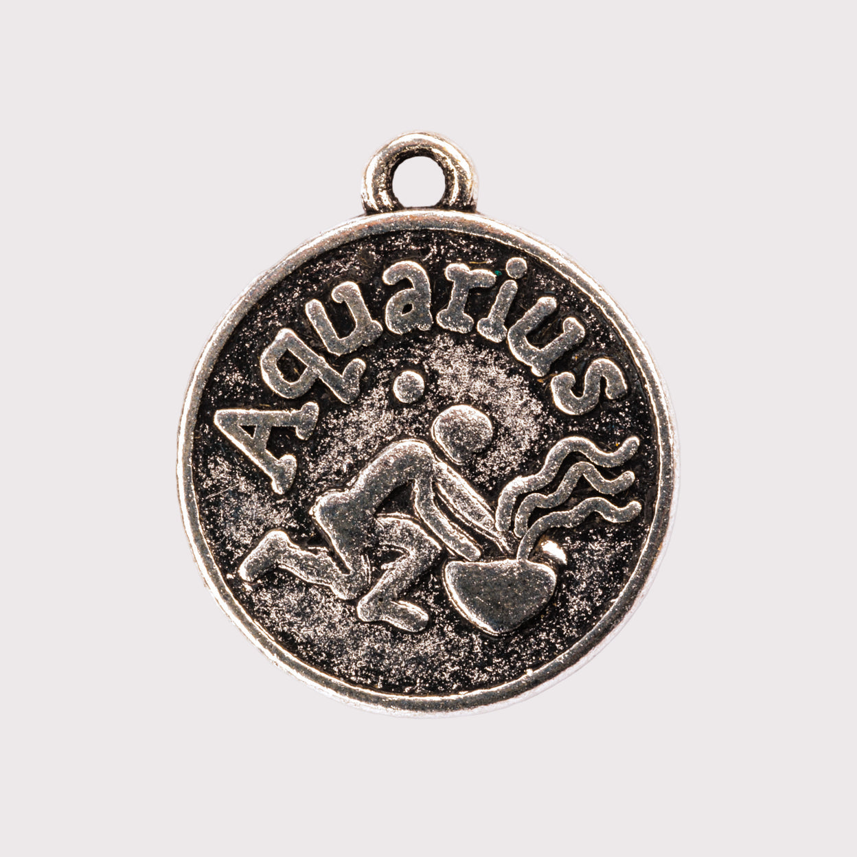 Antique silver Aquarius zodiac charm on a white background