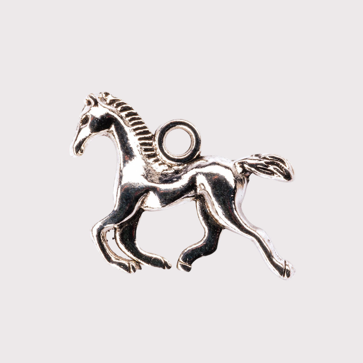 A silver charm in the shape of a horse.