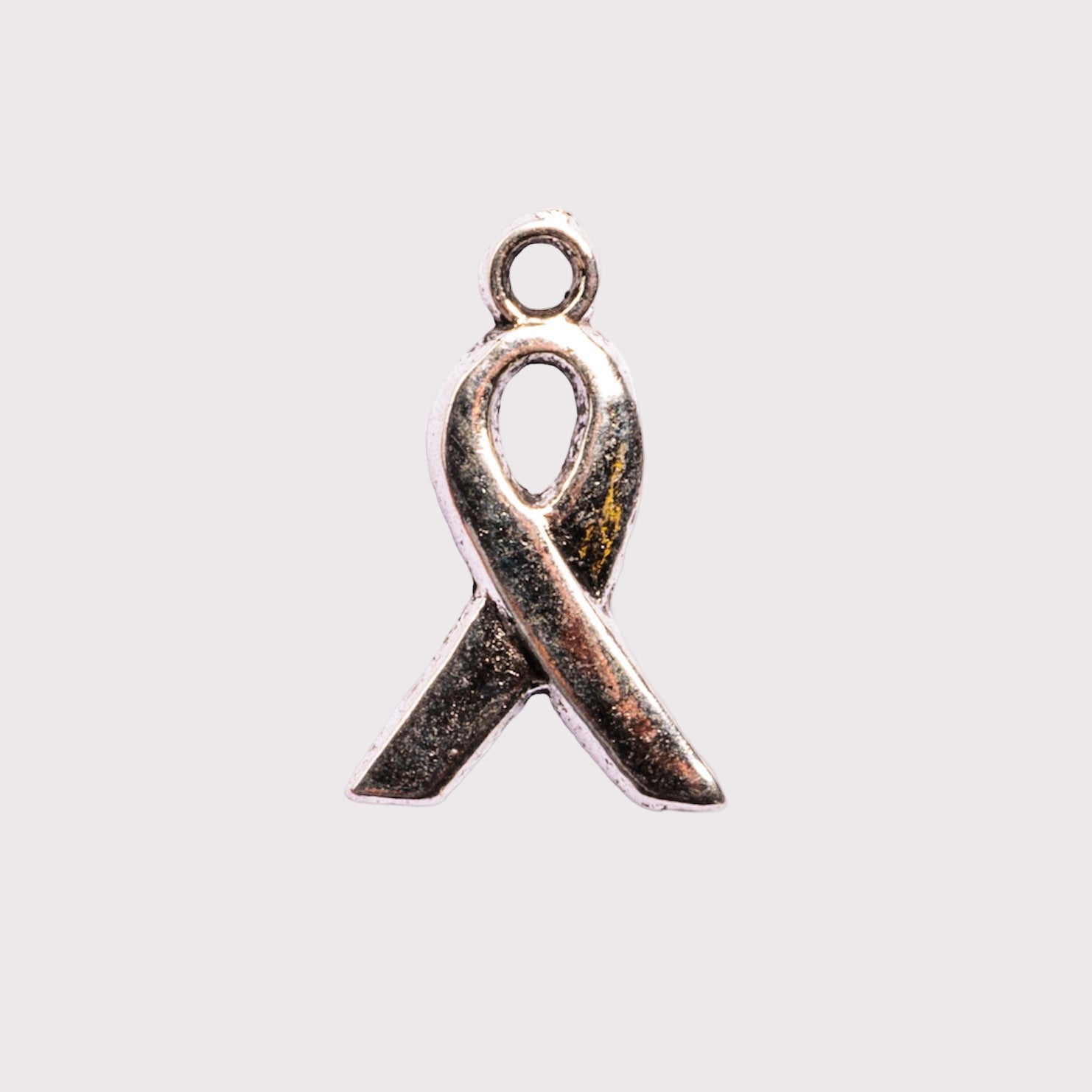 A silver-colored ribbon-shaped charm
