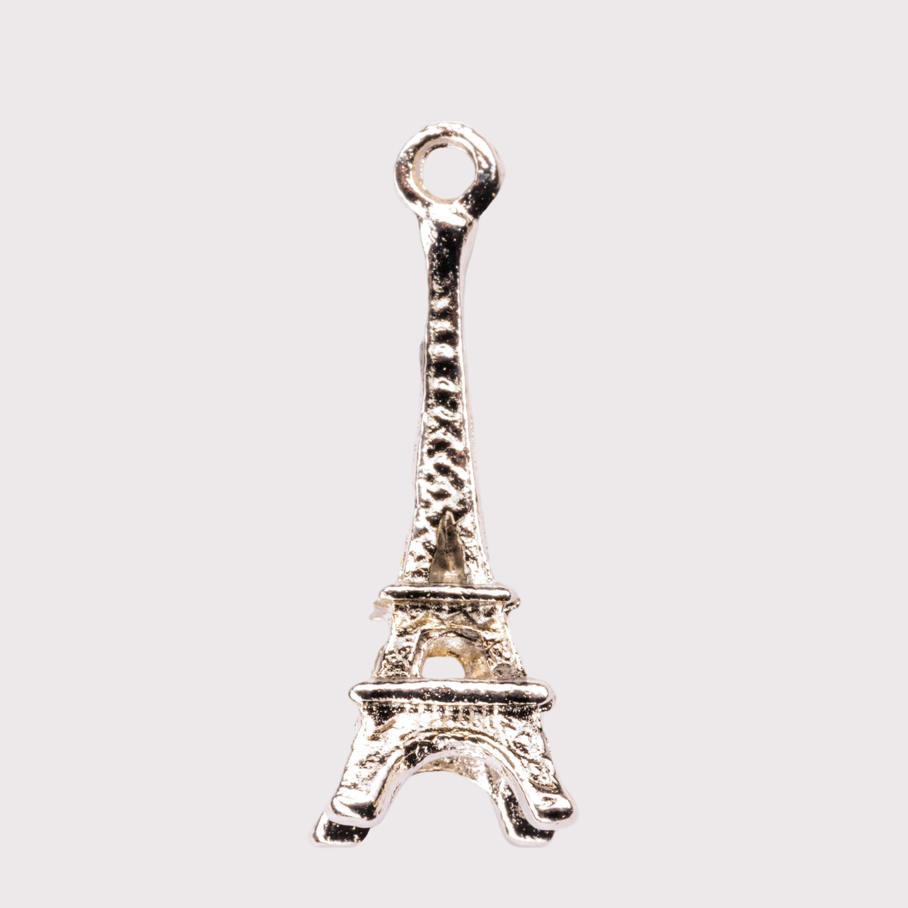 A silver-colored charm in the shape of the Eiffel Tower.