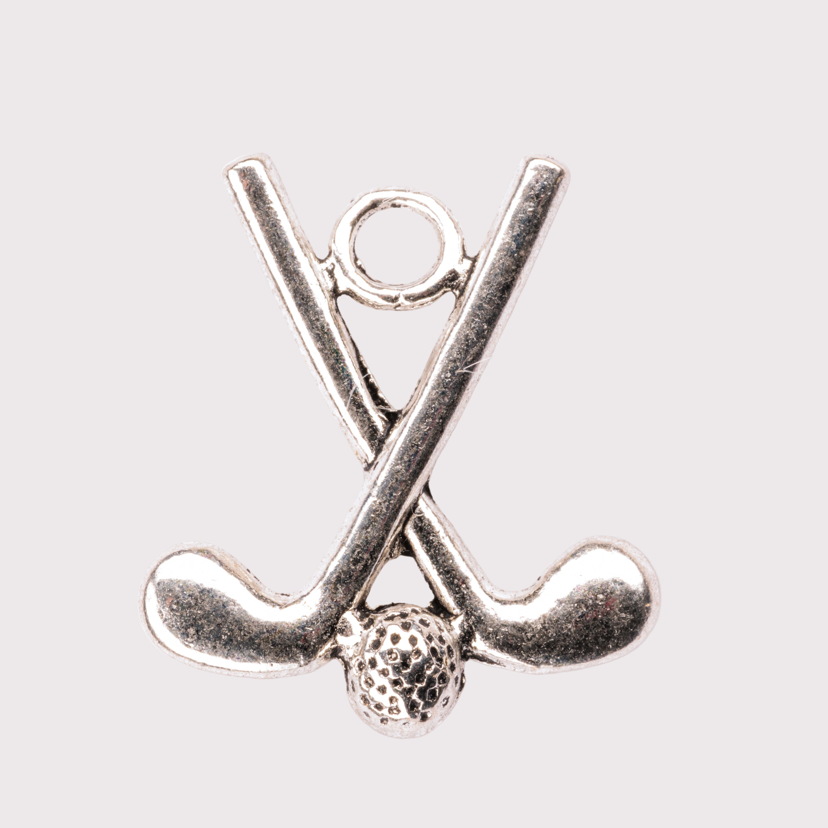 A silver charm in the shape of two crossed golf clubs with a golf ball.